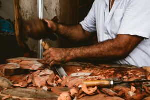 Um Homem Esta Esculpindo Um Pedaco De Madeira A2EAaN3ha_c