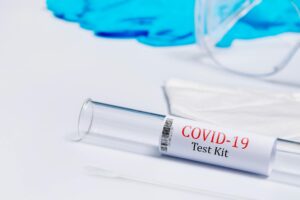 Close-up of a COVID-19 test kit with swab on a white surface, ideal for healthcare theme.