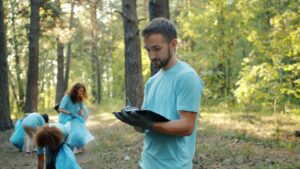 Volunteers picking up litter in a forest, promoting environmental conservation.