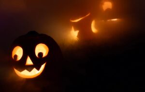 Eerie jack-o'-lanterns glowing in the fog, creating a spooky Halloween atmosphere.