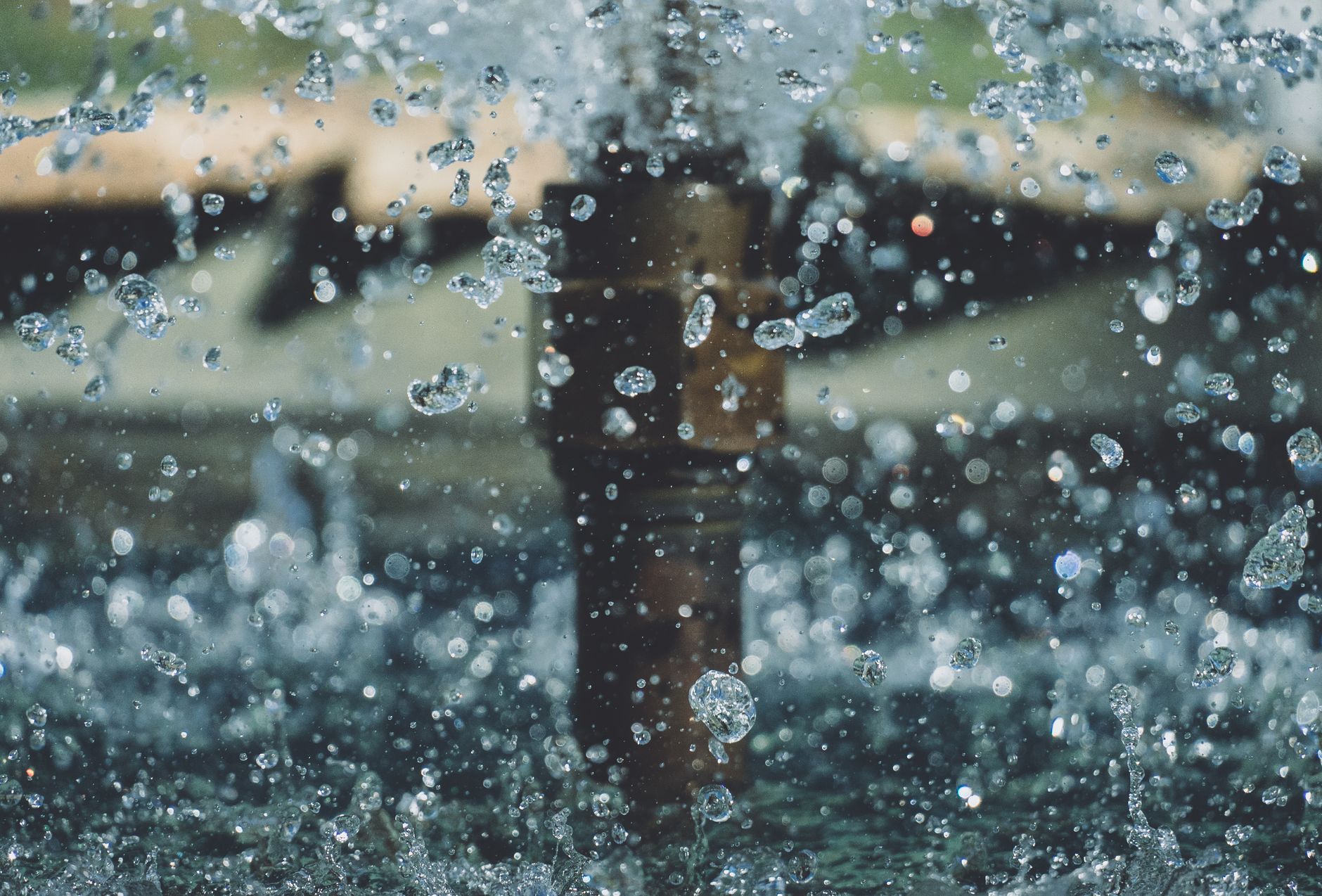 Close-up of water droplets mid-air from a fountain, capturing motion and clarity in an outdoor setting.