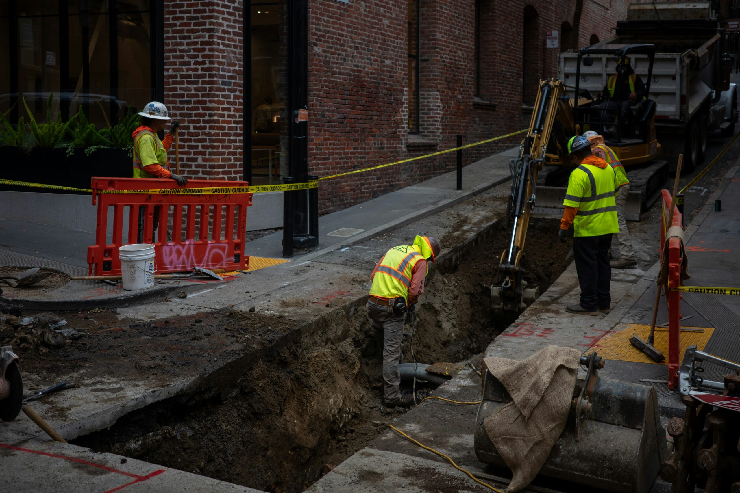 Construction workers digging a trench on a city street